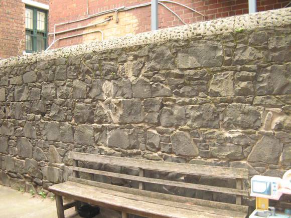 Basalt wall of coursed rubble, west boundary