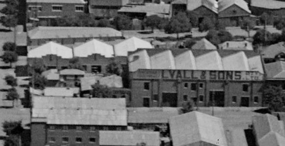 Fig 3. Corner site (Lots 1-2) (left), showing single storey masonry store on the Brougham Street frontage, rear two storey offices and modest skillion gabled outbuildings, 1927.  Also note the Lyalls and Sons produce store (right)( located on lots 3-6.